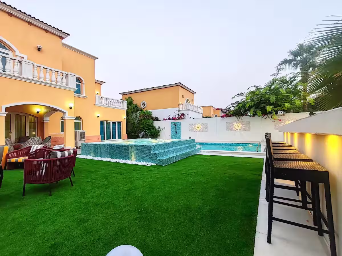 Evening view of Dubai villa with illuminated pool and water feature